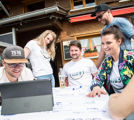 AB3 Kollegen im Ausflugslokal in den Alpen vor dem Tablet beim Brainstorming