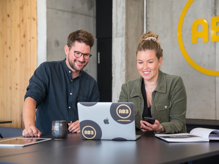 Frau und Mann am MacBook in der Alpenblickdrei Werbeagentur