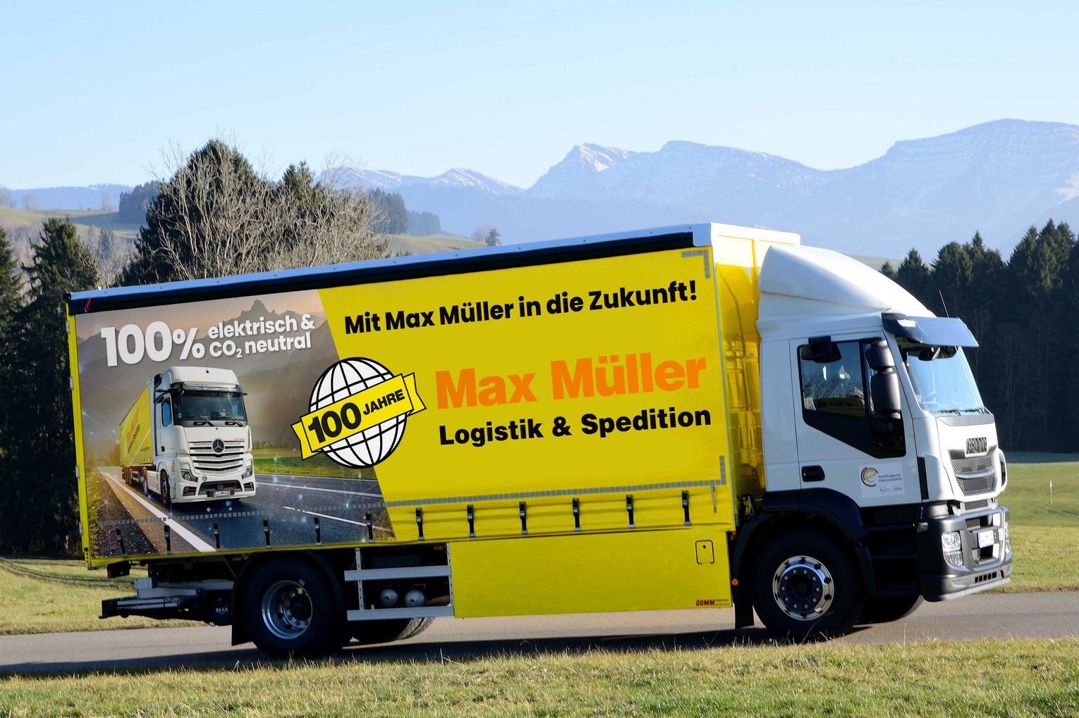 LKW mit Schriftzug vor Alpenpanorama