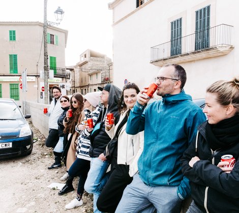 Coole Gang von AB3 Mitarbeitern an Mauer in Binissalem auf Mallorca mit Auto im Hintergrund